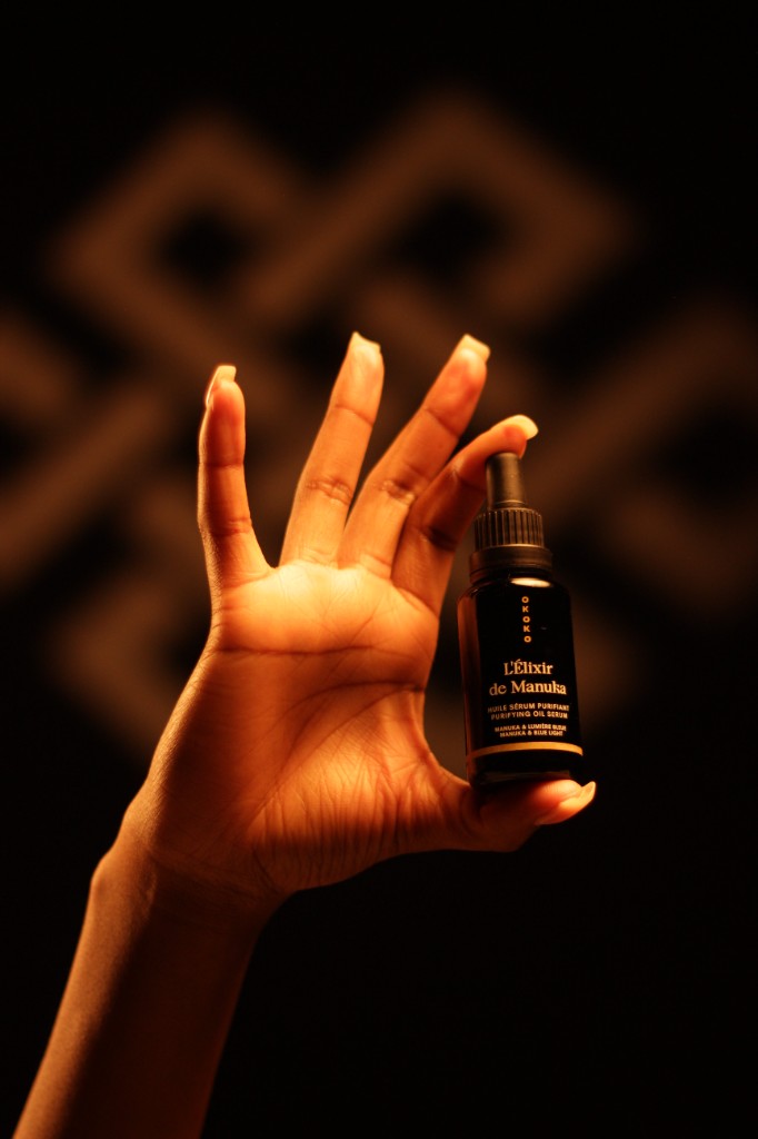 Hand holding OKOKO L'Élixir de Manuka purifying oil serum