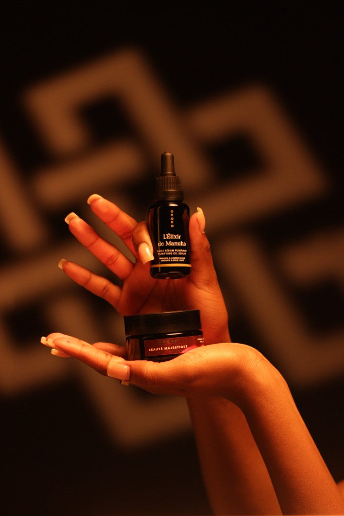 Hands holding OKOKO serum and Beauté Majestique jar